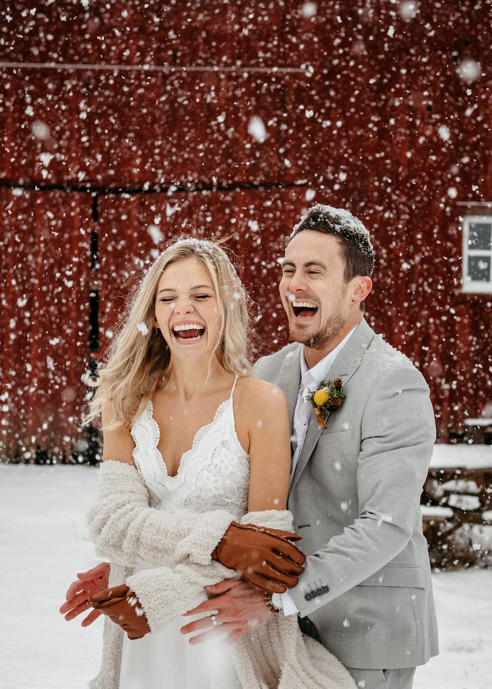 a bride and groom laughing in the snow
