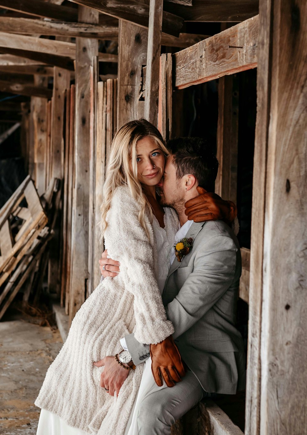 a man in a suit and tie kissing a woman in a white dress