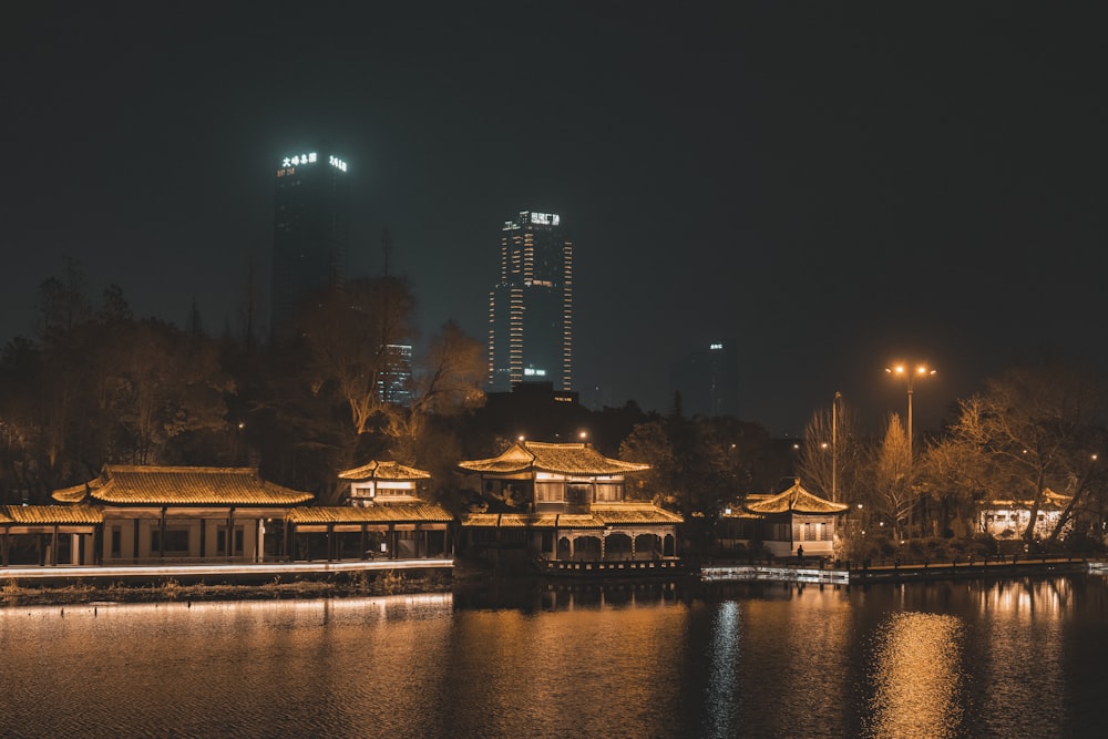 a night view of a lake with a building in the background