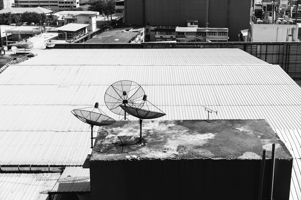 Une photo en noir et blanc d’une antenne parabolique sur un toit