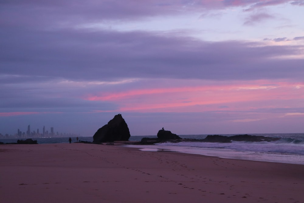 a beach with a rock formation in the distance