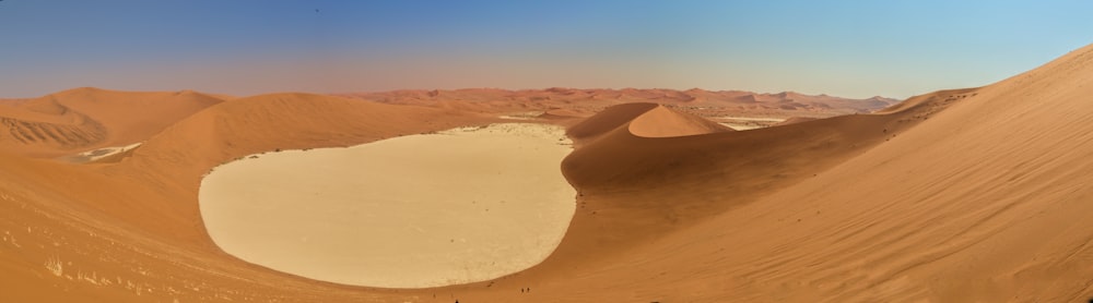 a group of people standing on top of a sand dune