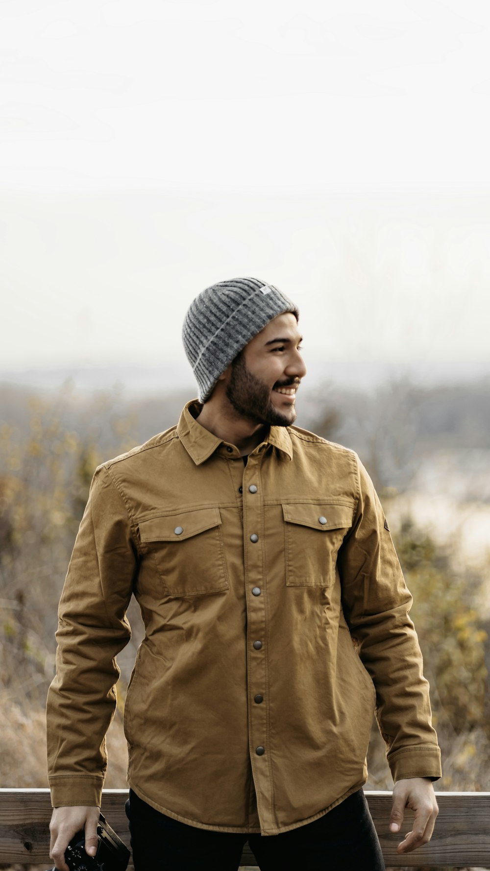 a man with a beard wearing a brown jacket