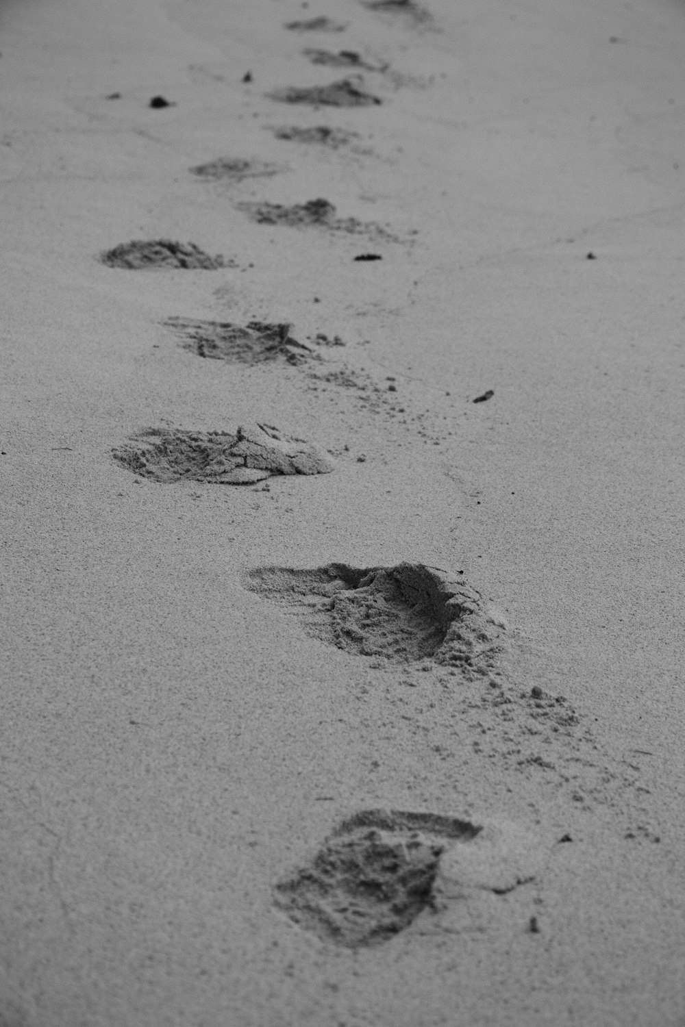 a black and white photo of footprints in the sand