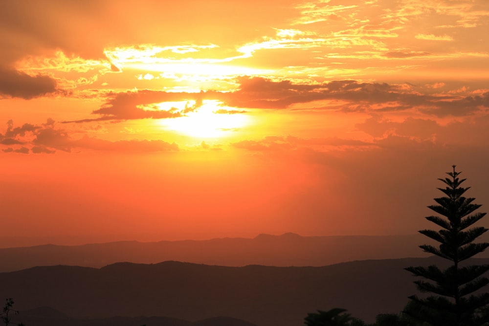 the sun is setting over a mountain range