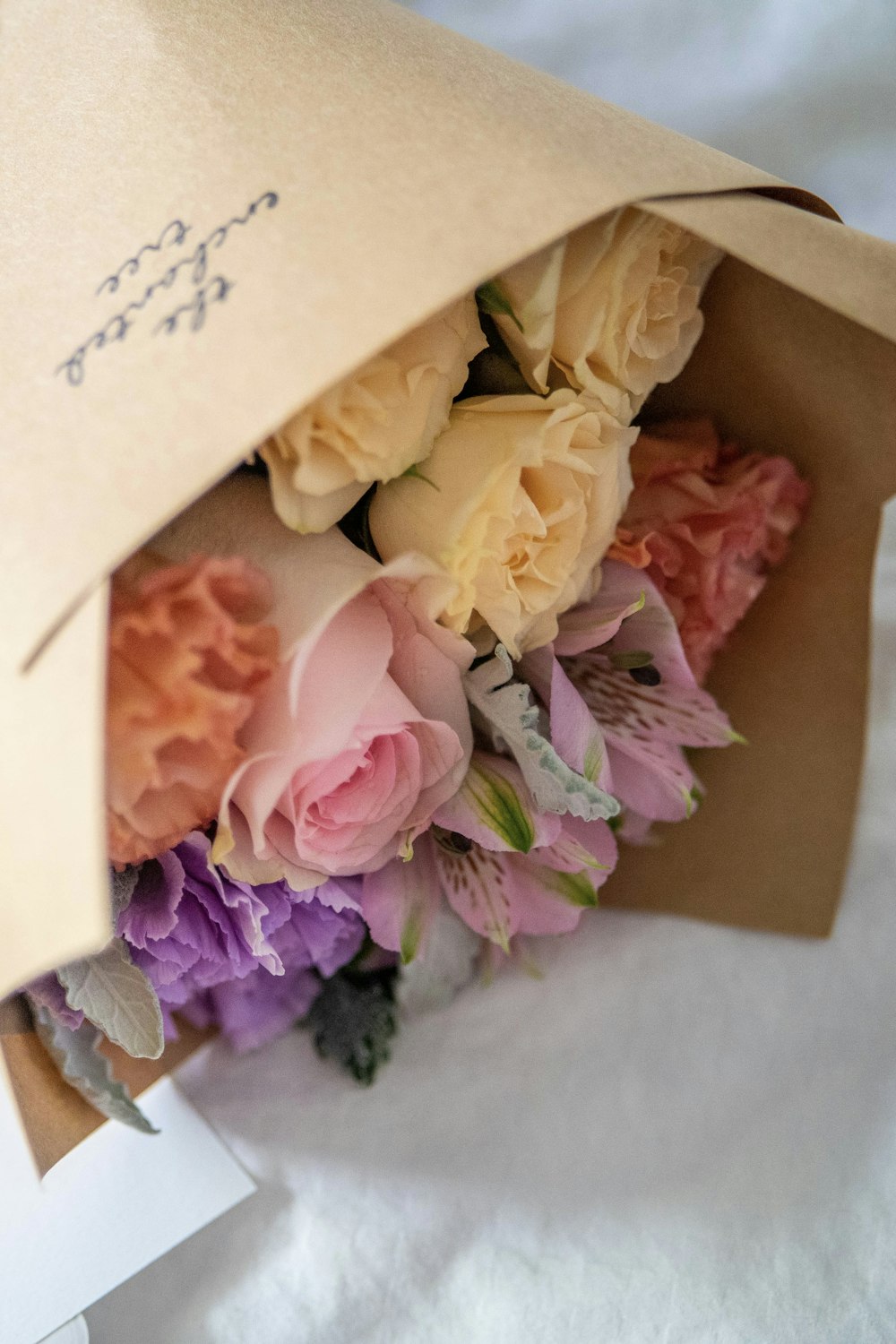 a bouquet of flowers is wrapped in a brown paper bag