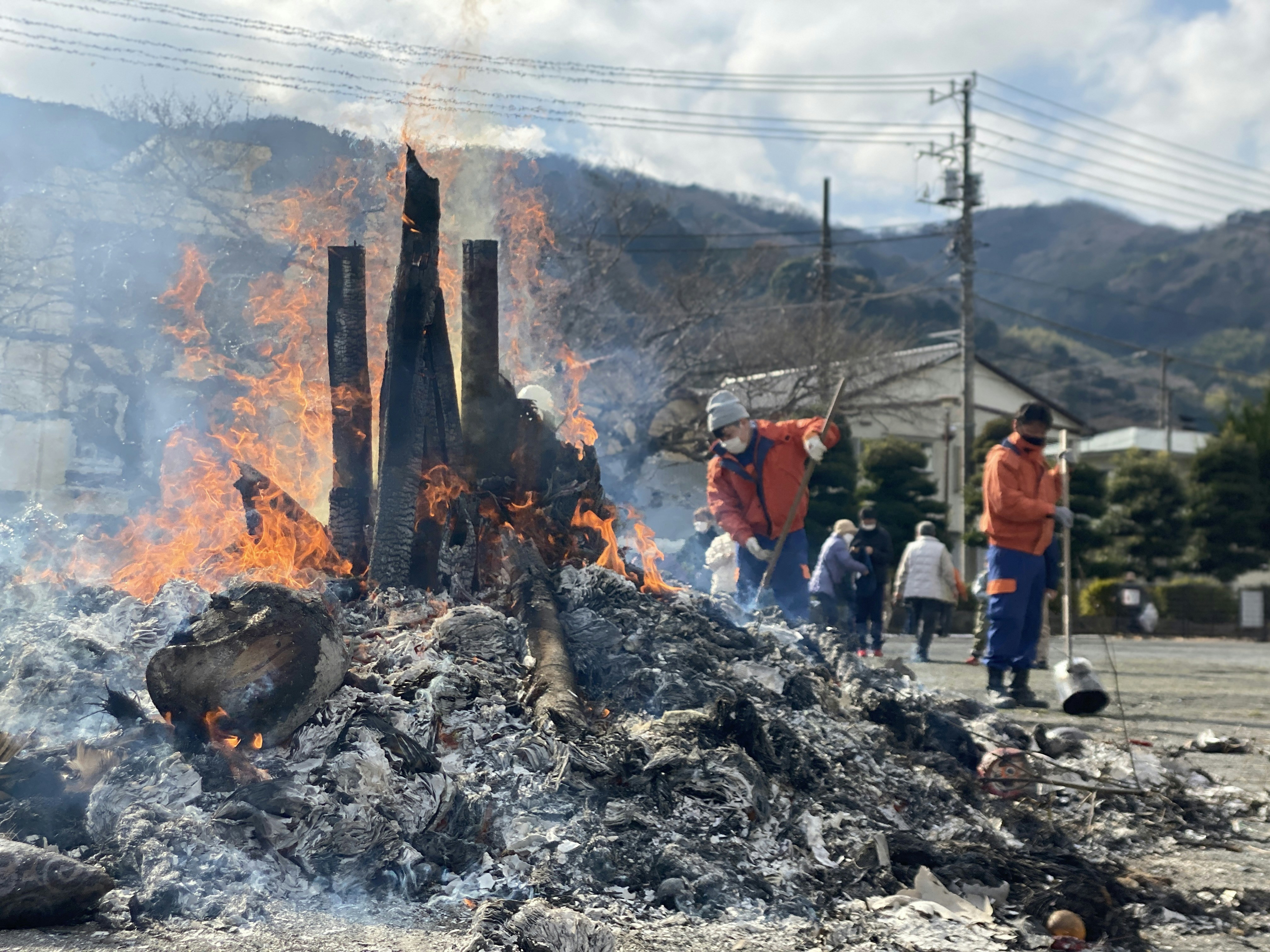 a group of people standing around a pile of fire