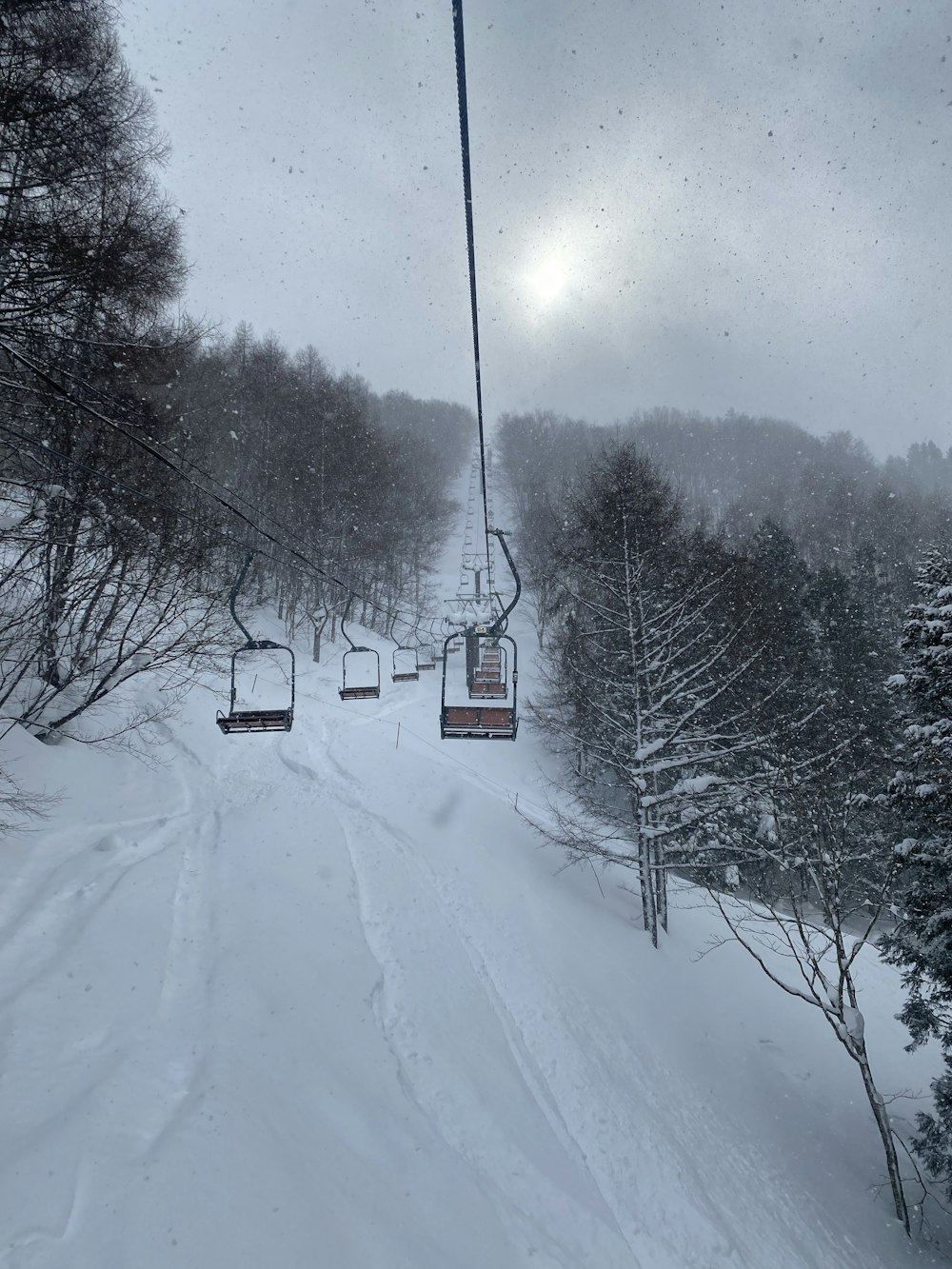 a ski lift going up a snowy mountain