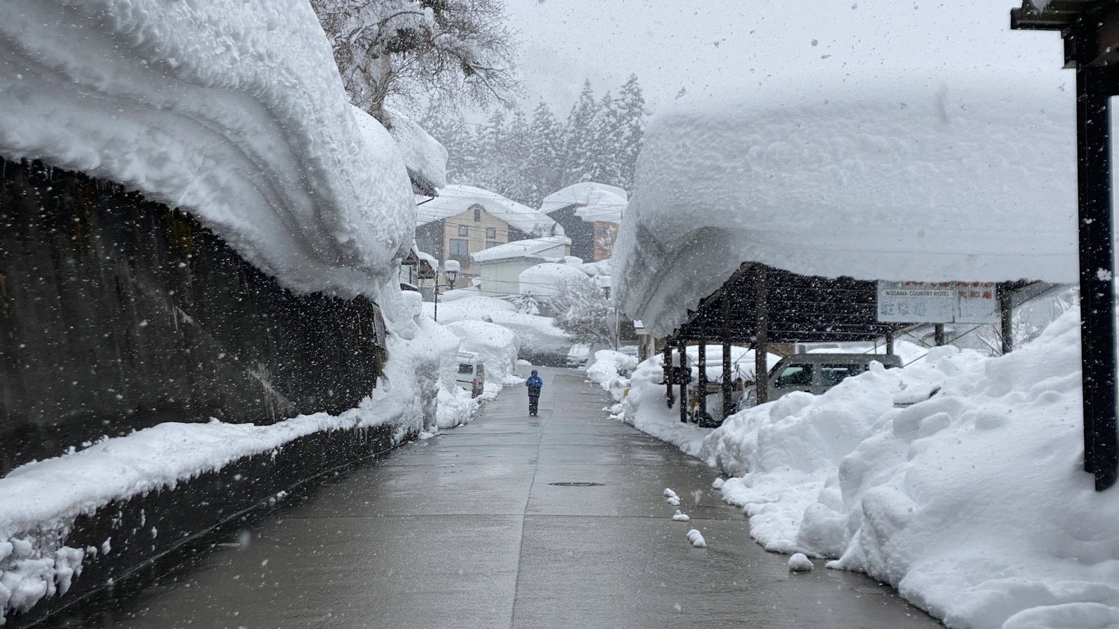 Snow along a street in Nozawa Onsen, Nagano, with buildings on either side