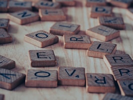 a close up of scrabble letters on a wooden surface