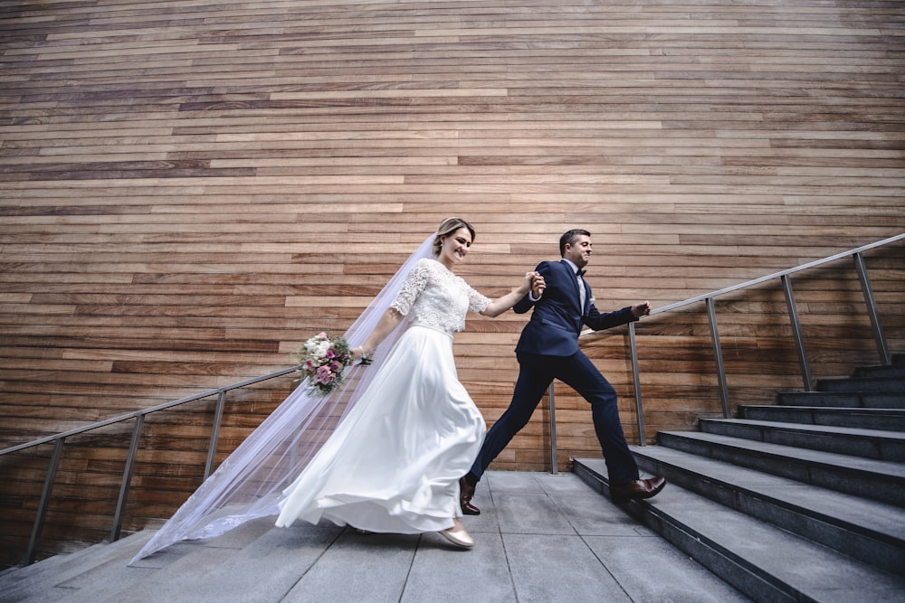 a bride and groom walking down a flight of stairs