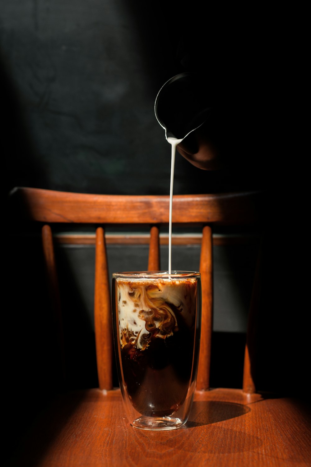 a cup of coffee being poured into a glass