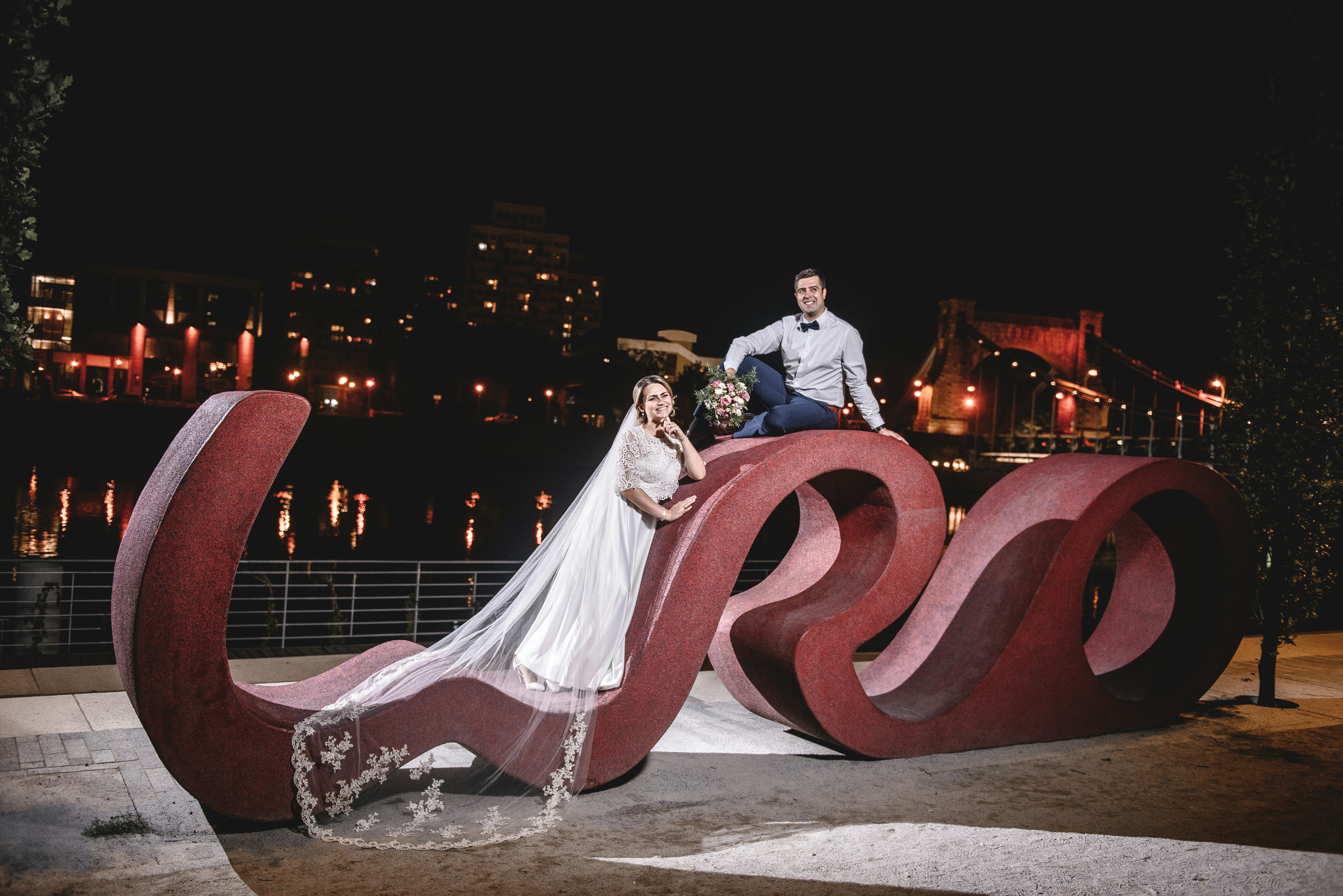 A bride and groom posing in front of a sculpture photo – Free Person ...