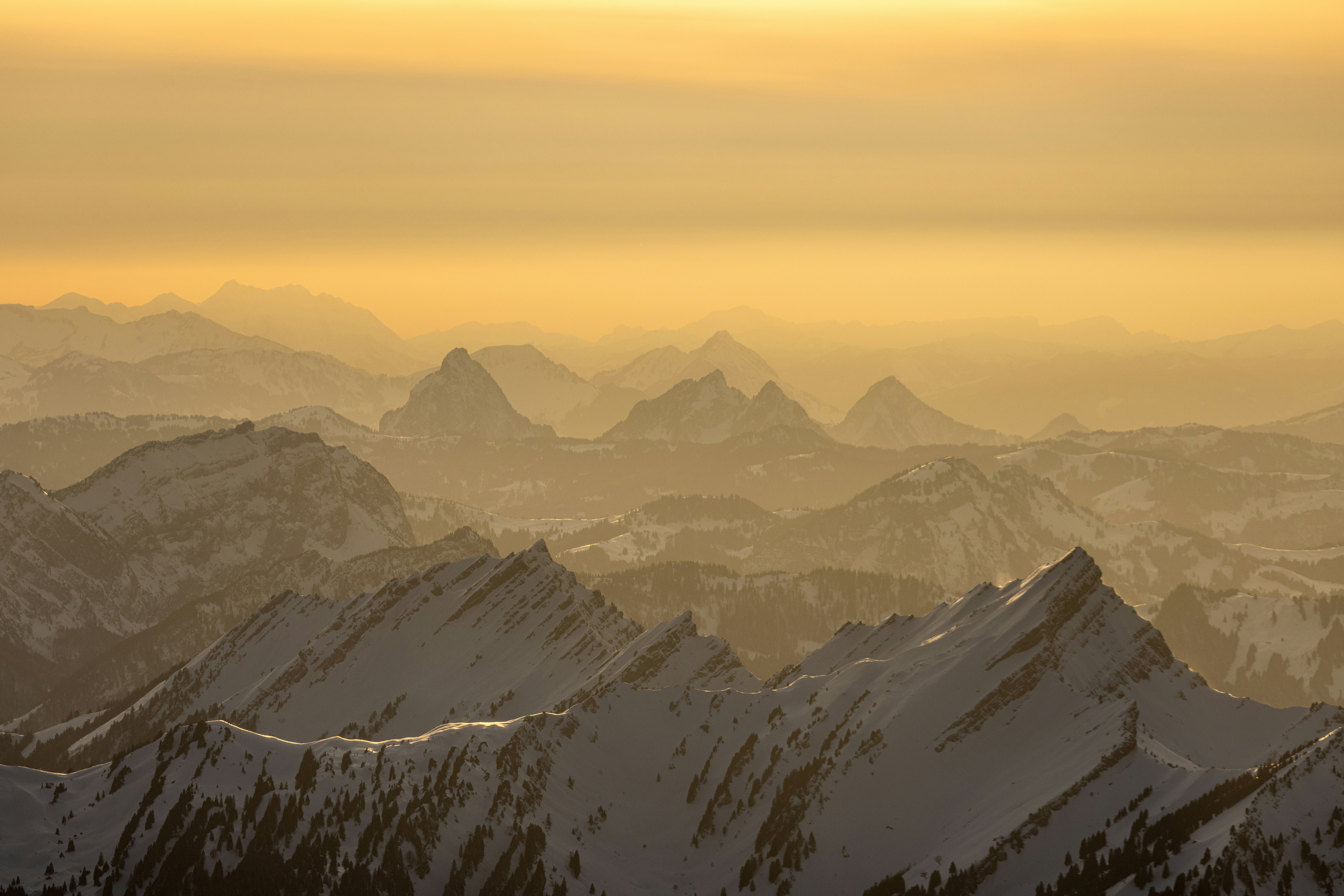 Un groupe de montagnes couvertes de neige sous un ciel nuageux