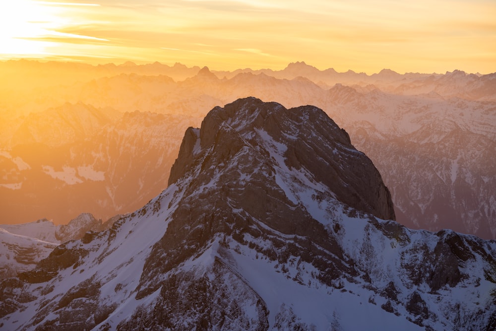 the sun is setting over a mountain range