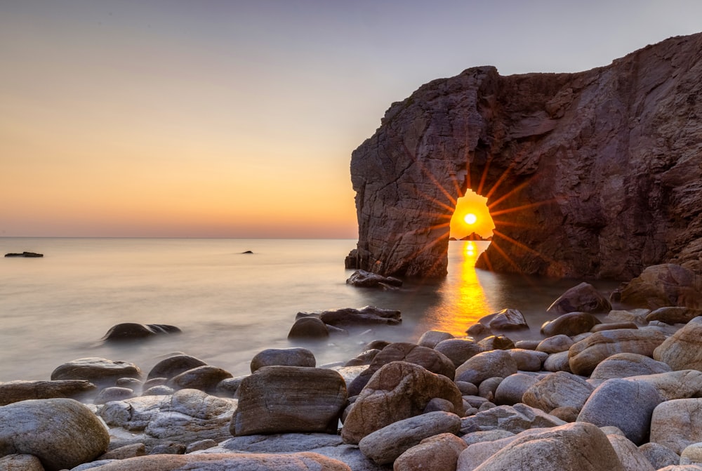 the sun shines brightly through a cave in the ocean