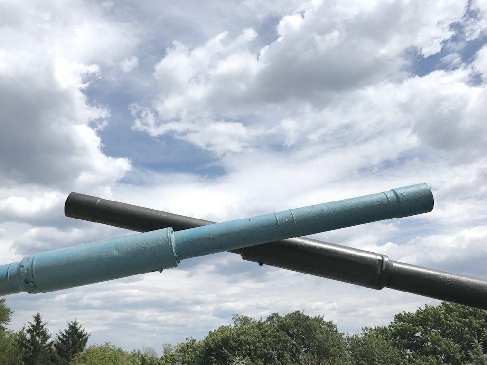 a large blue pipe sitting on top of a lush green field