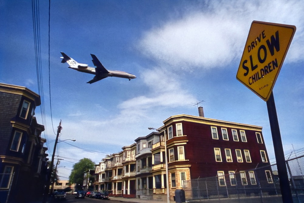 a plane is flying over a row of houses