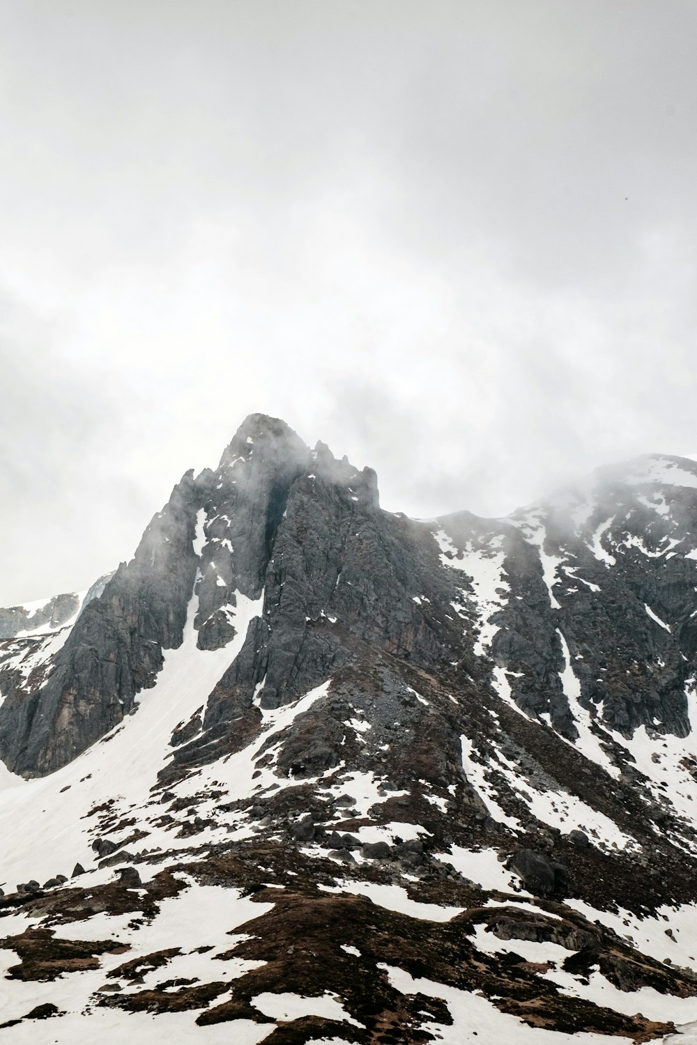 Una montagna coperta di neve e nuvole in una giornata nuvolosa
