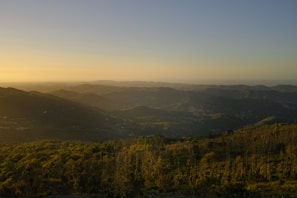 the sun is setting over the mountains in the distance
