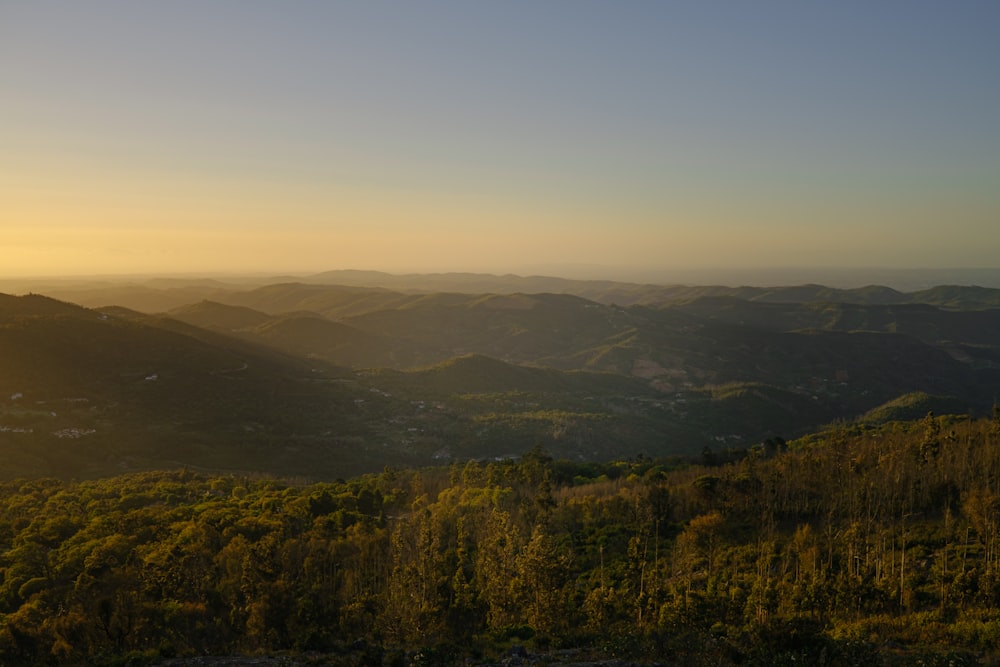 the sun is setting over the mountains in the distance