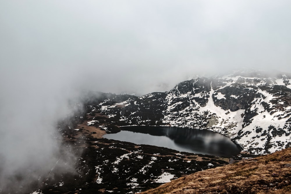 Un piccolo lago circondato da montagne innevate