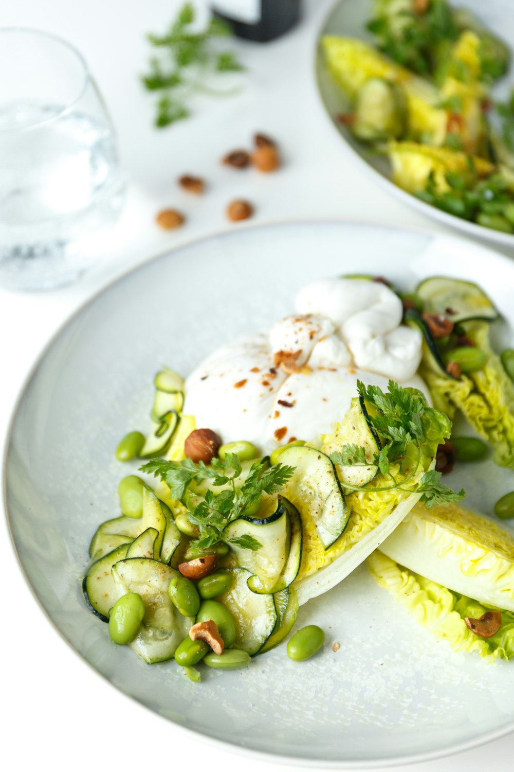 a white plate topped with cucumbers and other vegetables