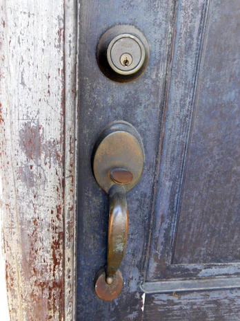 A close-up of a worn wooden door with peeling paint and scratches.