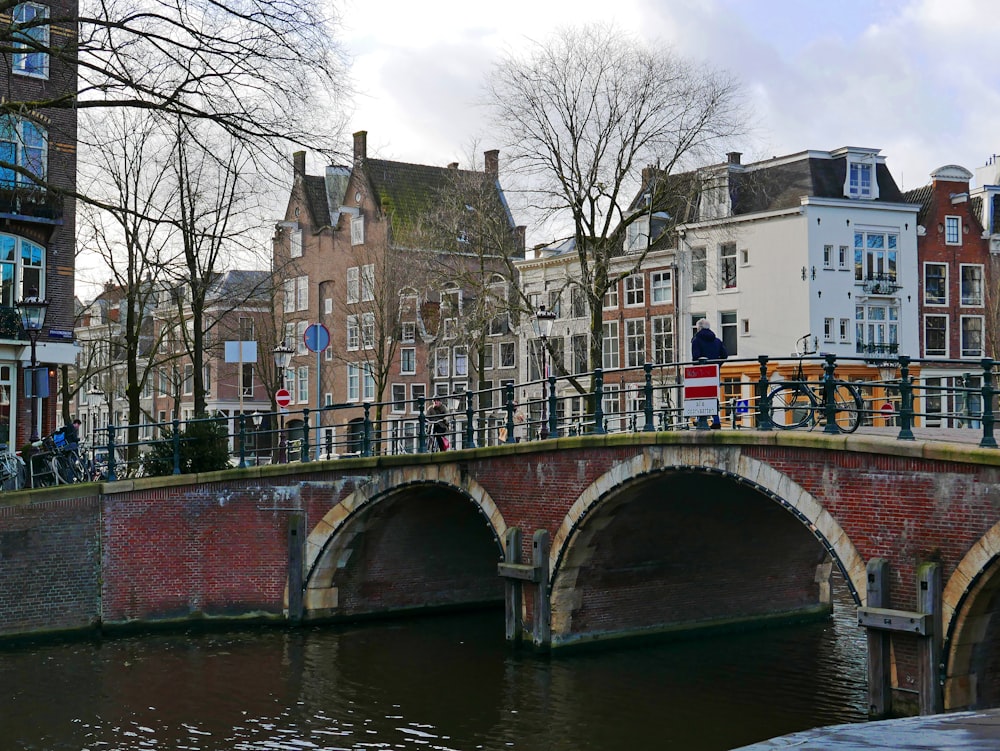 a bridge over a body of water with buildings in the background