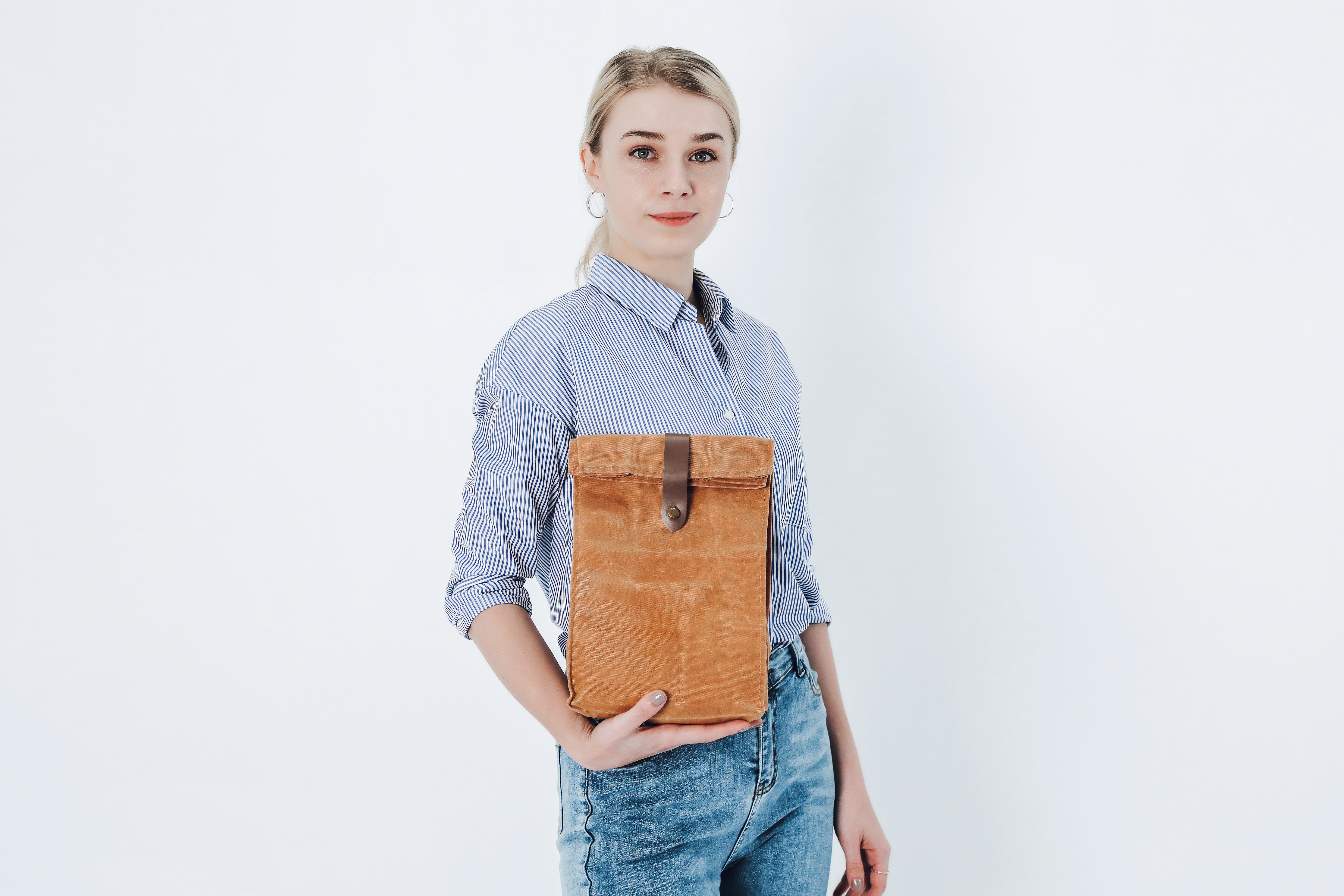 a woman holding a brown bag in her hands