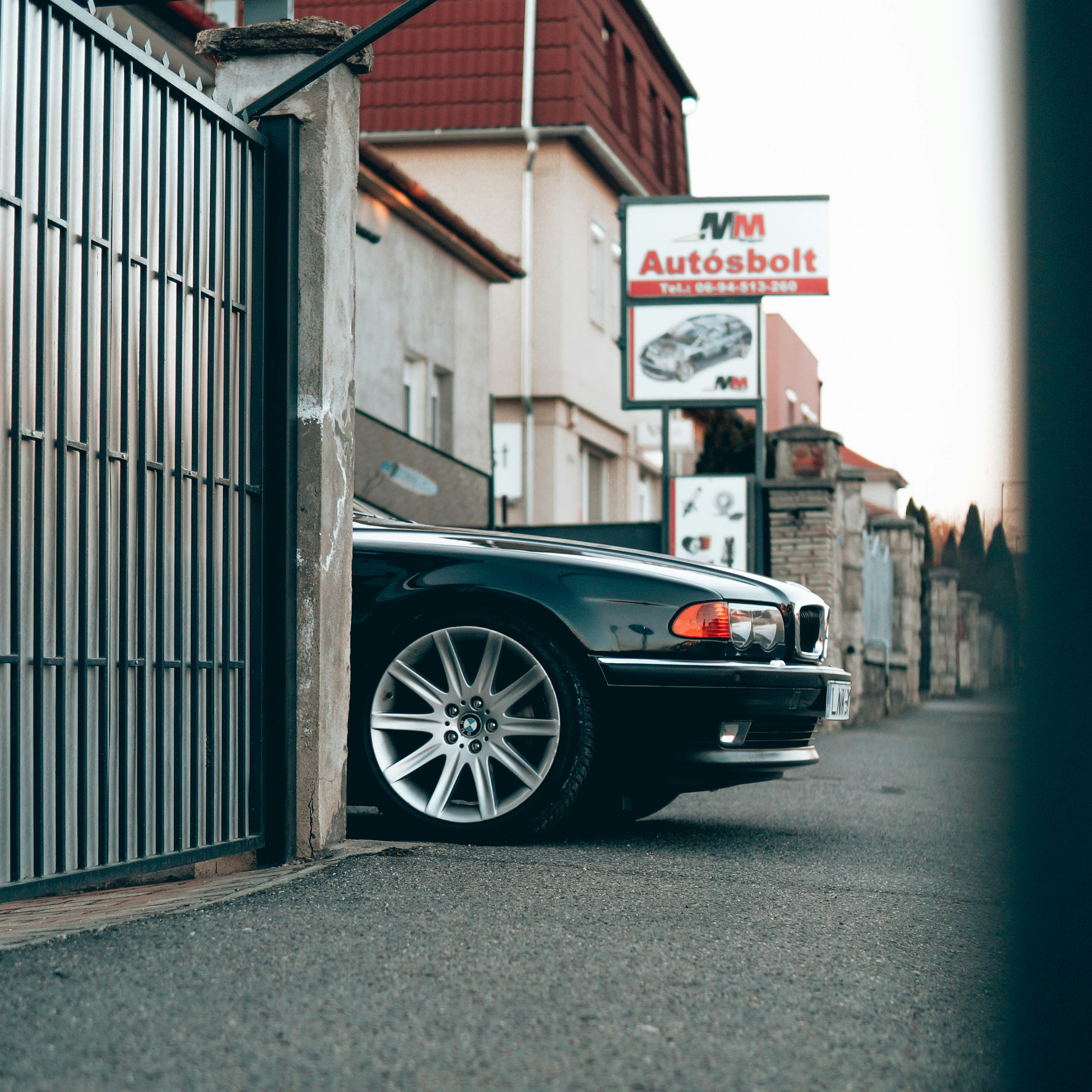 A black car parked in front of a building photo – Free Grey Image on ...