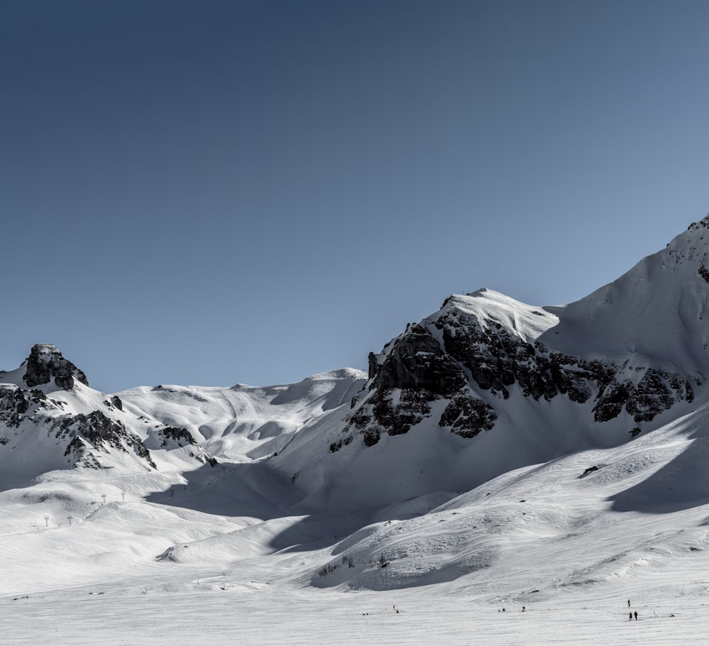 a group of people skiing down a snow covered slope