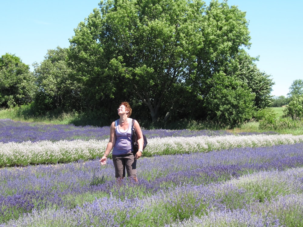 a woman standing in a field of lavender flowers