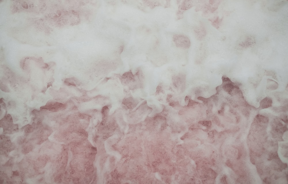 a close up of a pink and white wall
