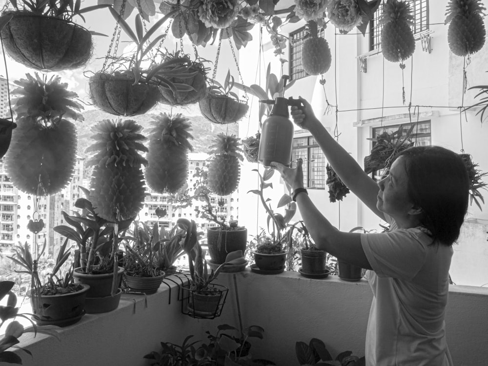 a little boy that is reaching up to some plants