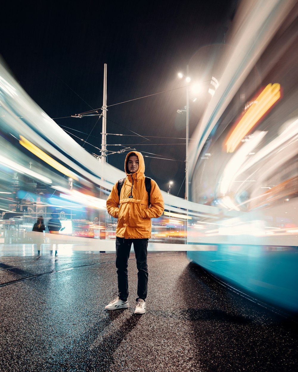 a man standing in the middle of a street at night