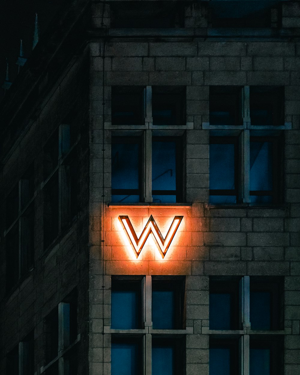 a brick building with a neon sign on the side of it