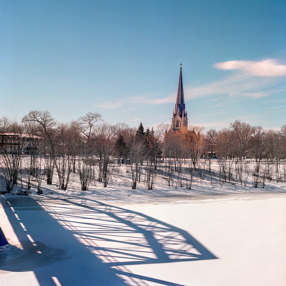 a view of a snowy field with a church in the background