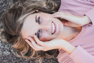 a woman laying on the ground with her hands on her face