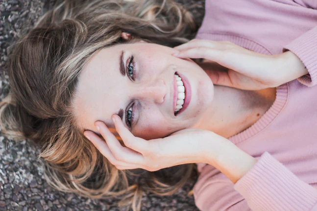 a woman laying on the ground with her hands on her face