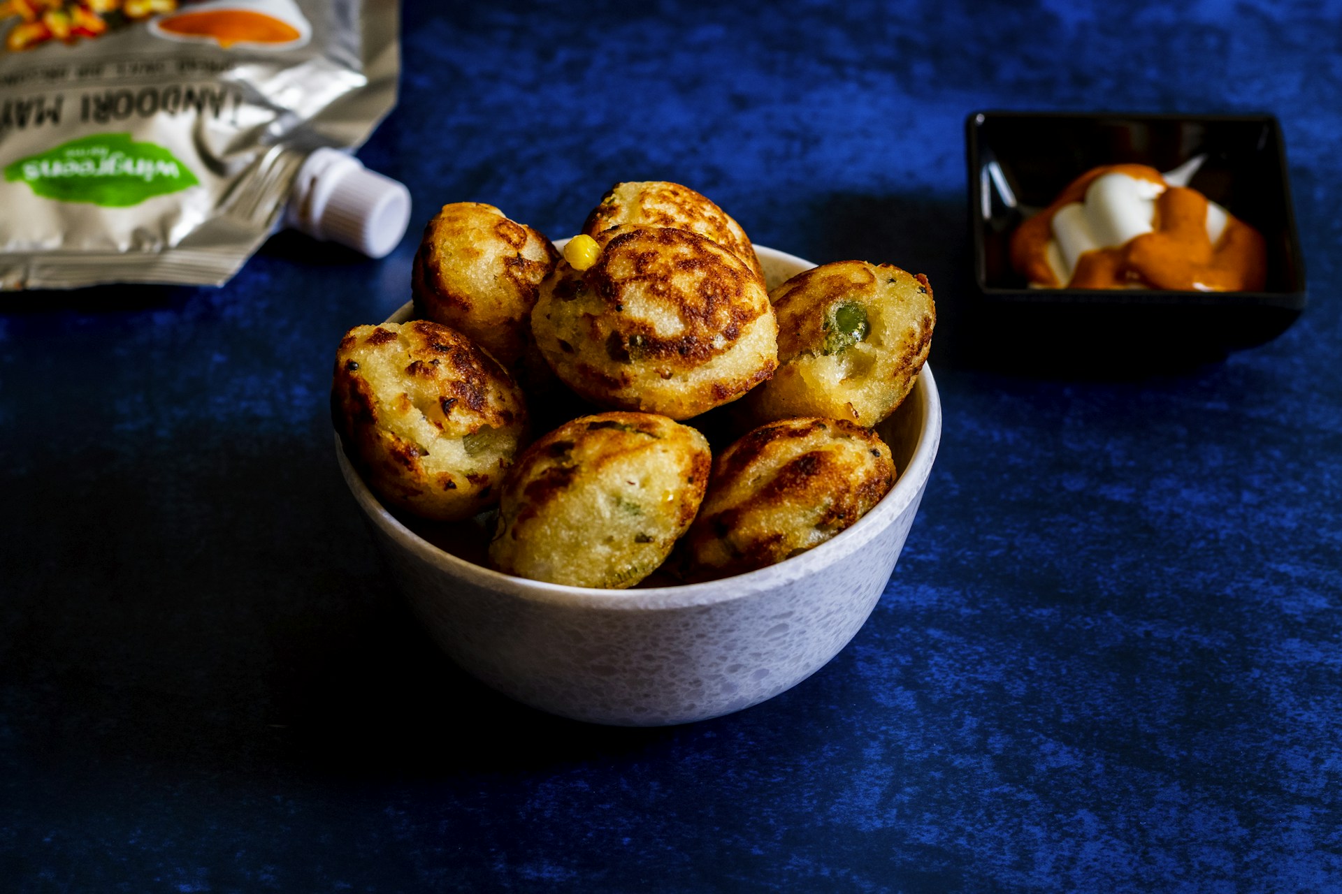 a bowl of food sitting on a table next to a bag of chips