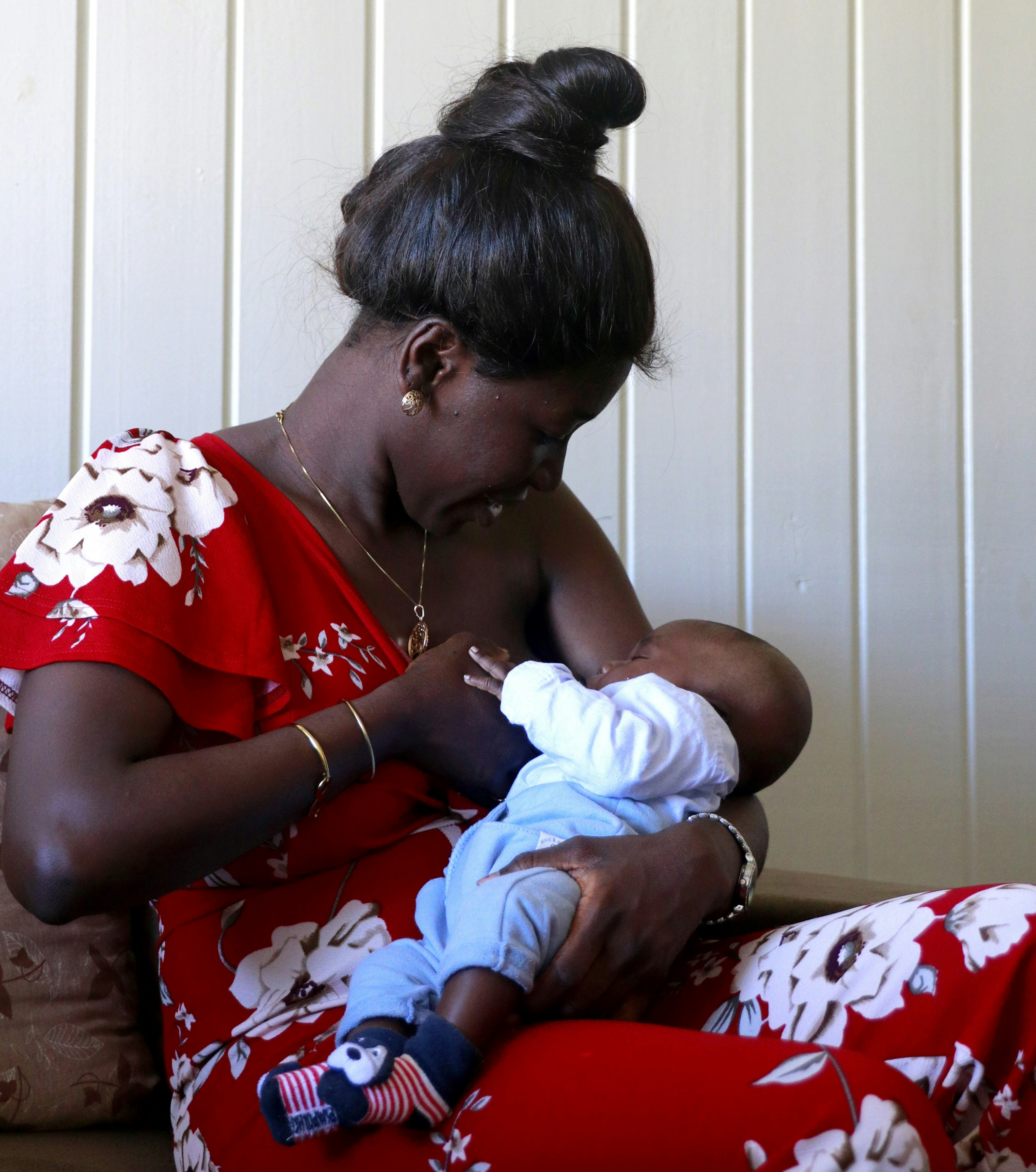 a woman in a red dress holding a baby