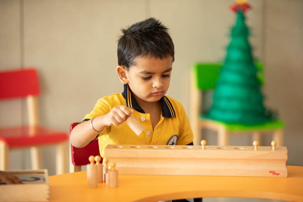 a young boy playing with wooden toys at a table