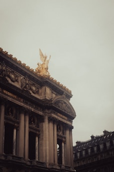 un grand bâtiment avec une statue au sommet