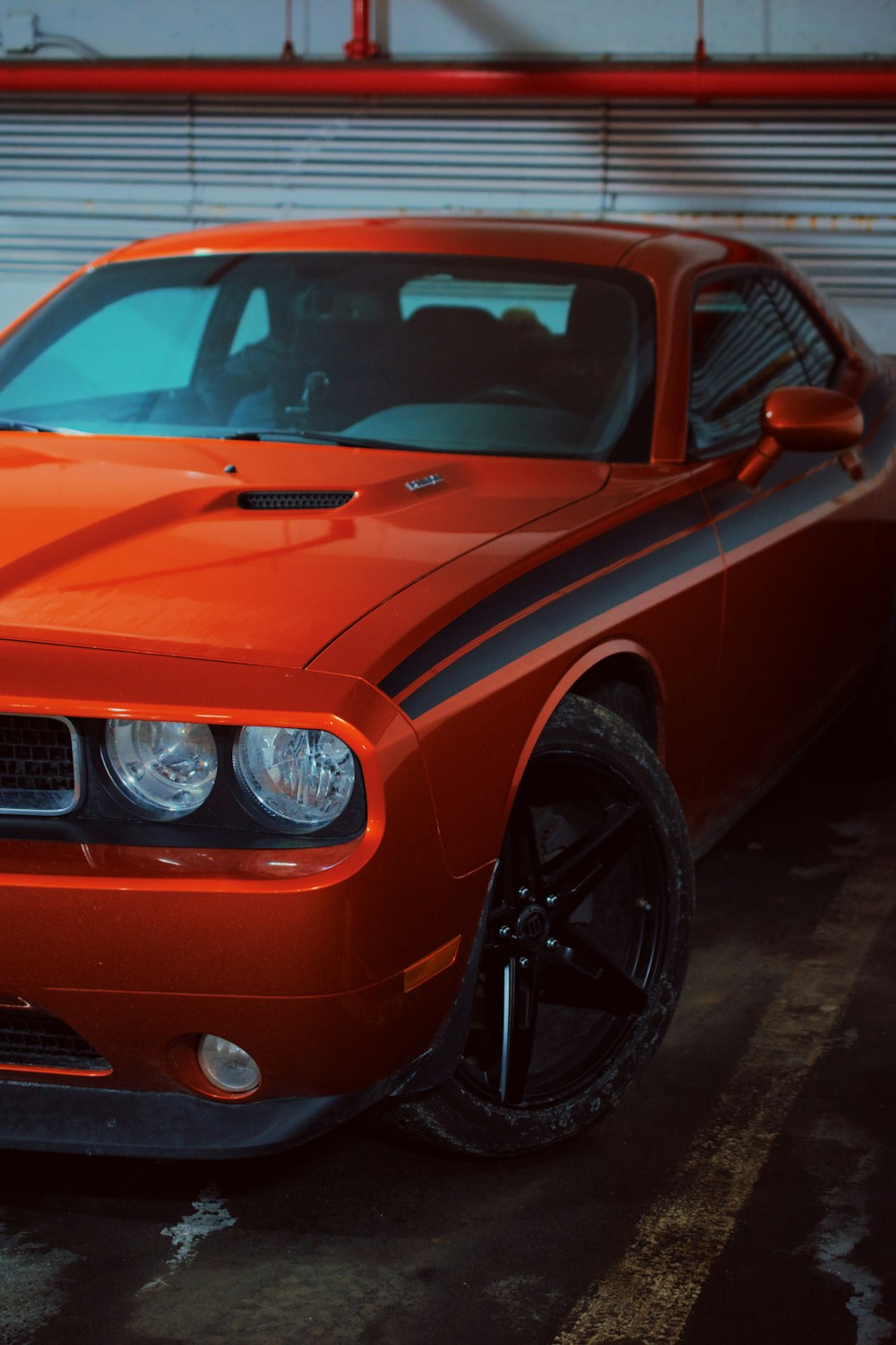 an orange sports car parked in a garage