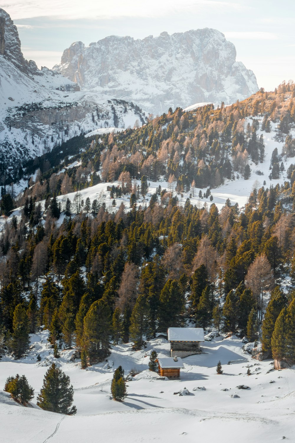 a snow covered mountain with a cabin in the foreground