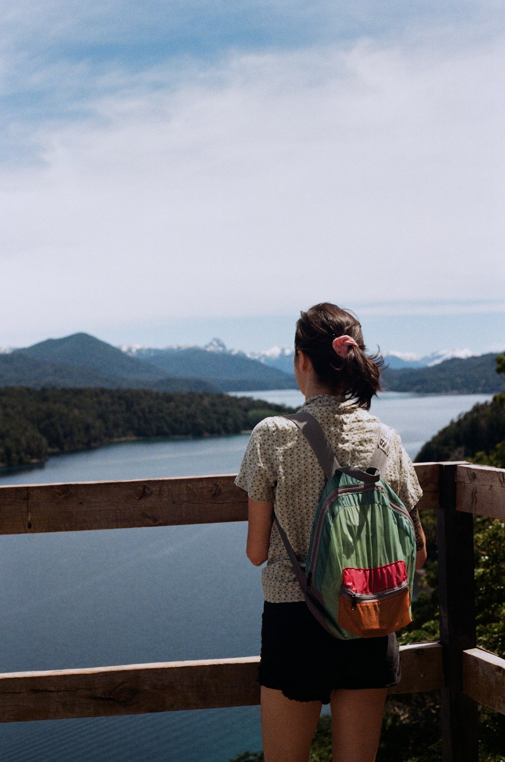 a woman with a backpack looking out over a lake