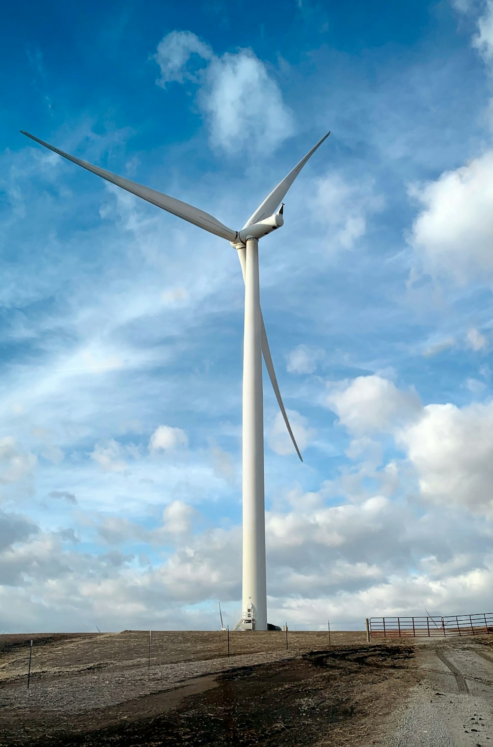 une grande éolienne sur un chemin de terre