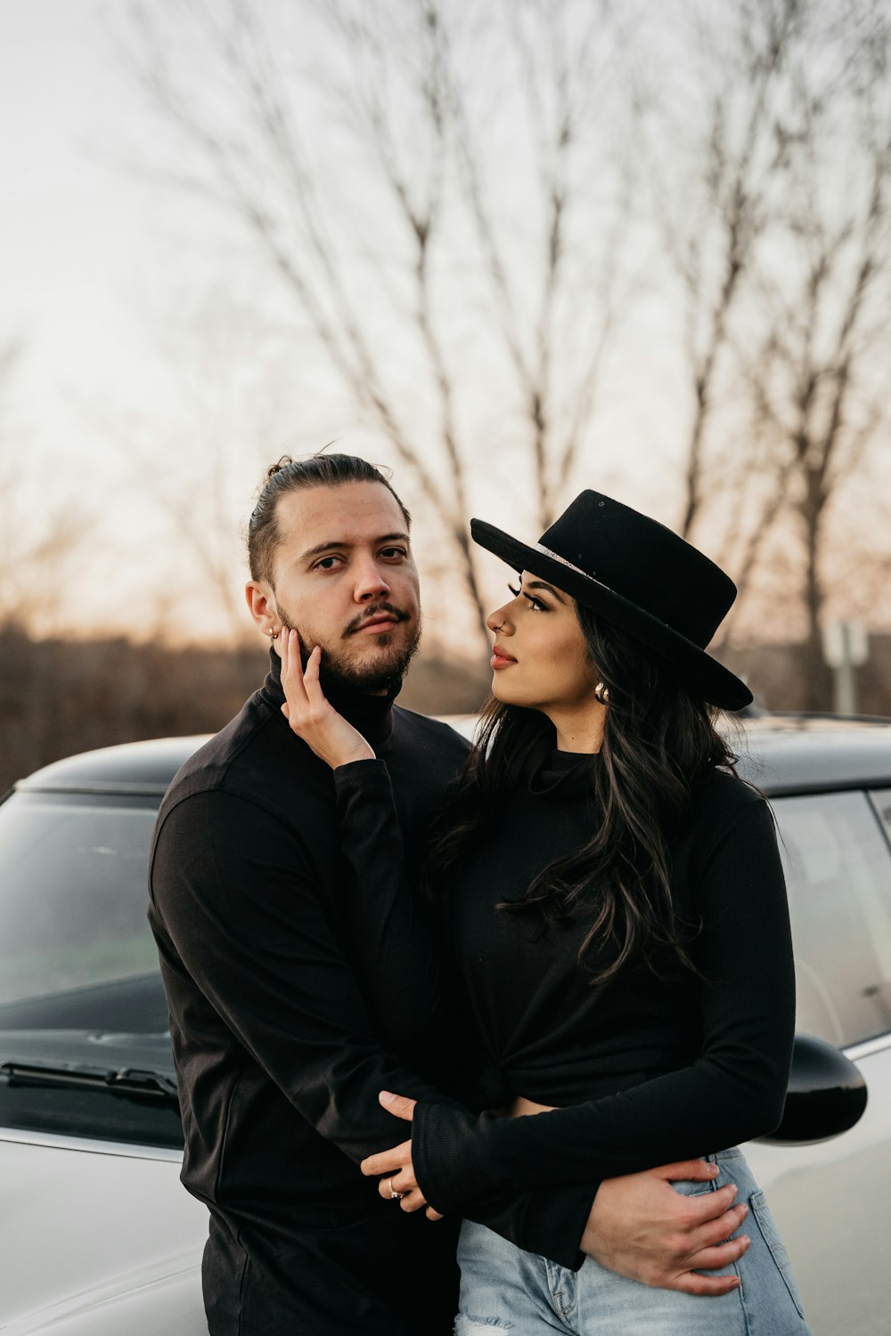 a man and a woman standing next to a car