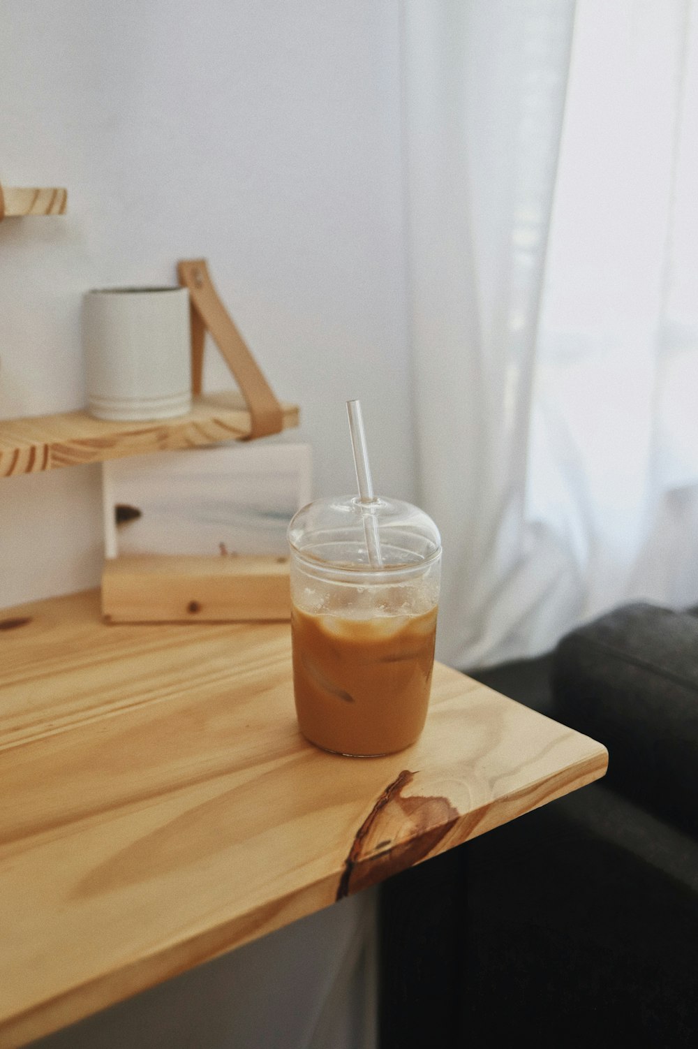 a cup of iced coffee sitting on a wooden table